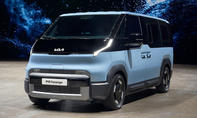 Der Kia PV5 Passenger (2025) steht in Studioumgebung, von vorne links fotografiert.