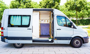 Ein Van mit dem Moby Camper-Ausbau von der rechten Seite. Die Schiebetür ist geöffnet.