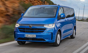 VW E-Caravelle (2025) fährt auf einer Straße, Ansicht von vorne links.