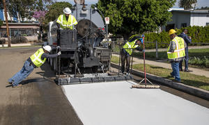 Straßenbauarbeiter malen Straße in Los Angeles weiß an.