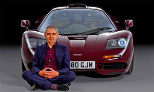 Rowan Atkinson sitzt vor dem McLaren F1