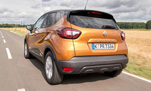 Der Renault Captur (2017) fährt über eine Landstraße, von hinten links fotografiert.