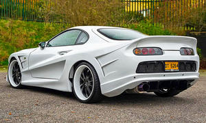 Die Toyota Supra Mk4 mit Abflug-Bodykit stehend von schräg hinten.