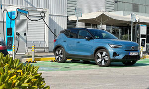 Der Volvo XC40 Recharge Pure Electric statisch von schräg vorne fotografiert; steht an einer Ladesäule