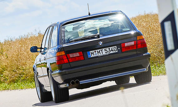 Der BMW M5 touring (E34) von hinten fahrend fotografiert.