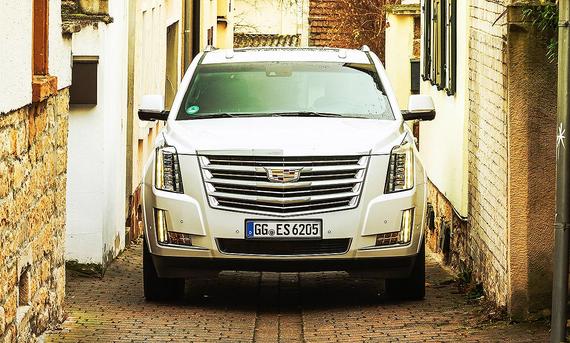 Cadillac Escalade; Frontalansicht eines SUV in einer sehr engen Gasse.