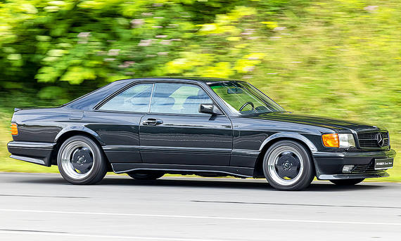 Der Mercedes 560 SEC AMG fahrend von schräg vorne