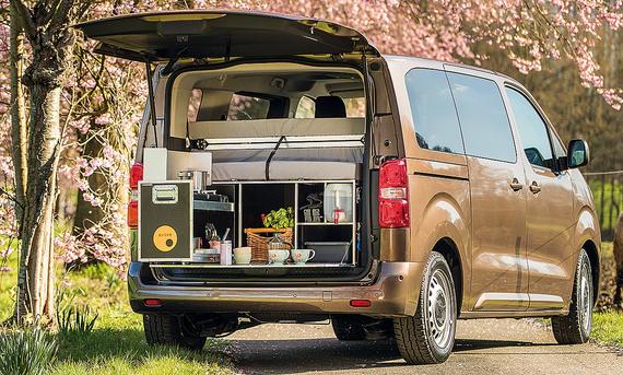 Toyota Campingzubehör; Toyota Proace Verso, stehend, mit offener Heckklappe. Im Van befindet sich eine Campingbox.