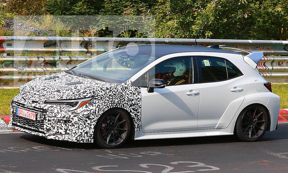 Toyota GR Corolla Facelift (2024); Blick von schräg links vorne auf den fahrenden, teilweise getarnten Corolla.