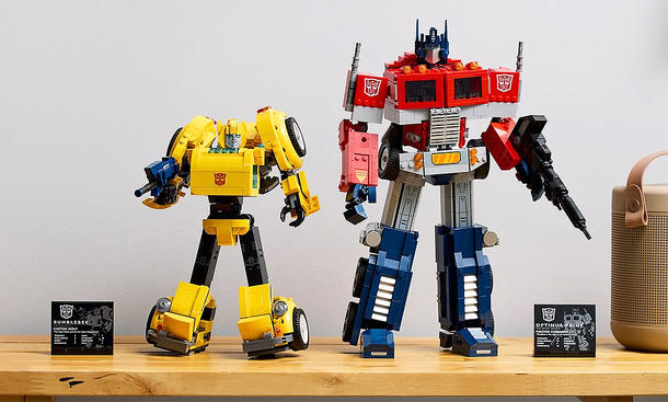 Lego Transformers Bumblebee & Optimus Prime stehen auf einem Tisch in ihrer Roboter-Form aufgebaut.