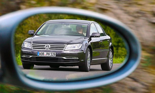 Der VW Phaeton 3.0 TDI 4Motion fahrend von schräg vorne im Rückspiegel fotografiert.