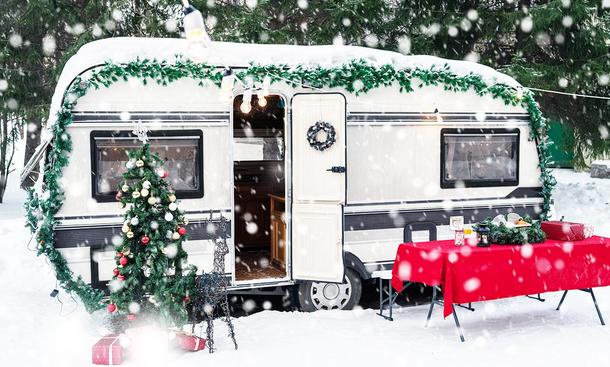 Wohnwagen zur Weihnachtszeit. Das Bild zeigt einen geschmückten Caravan in der Außenansicht. 