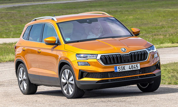 Der Skoda Karoq (2021) fährt durch eine Linkskurve, von vorne rechts fotografiert.