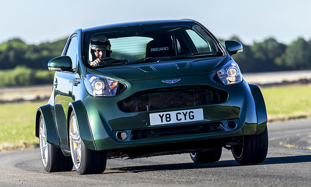 Der Aston Martin Cygnet V8 fährt durch eine Linkskurve, von vorne fotografiert.