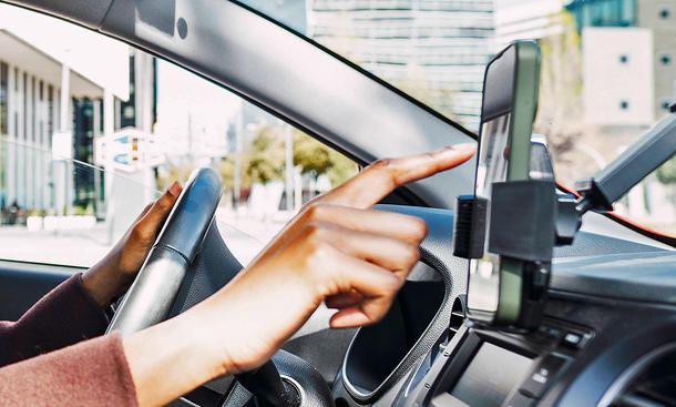 Smartphone im Handyhalter wird im Auto bedient