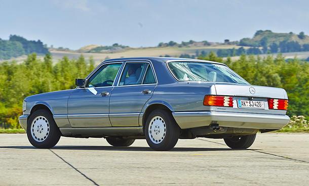 Der Mercedes 420 SE (W126) fahrend von schräg hinten fotografiert.