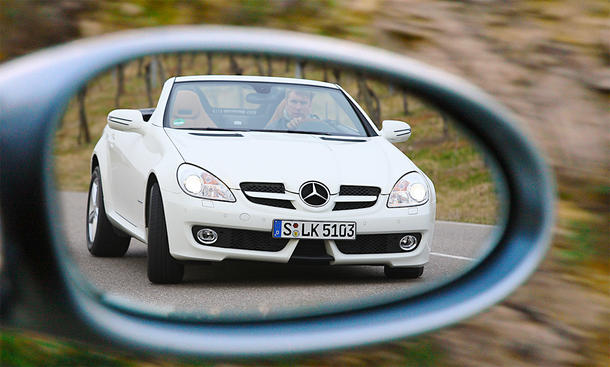 Der Mercedes SLK 200 Kompressor fahrend von schräg vorne im Rückspiegel fotografiert.