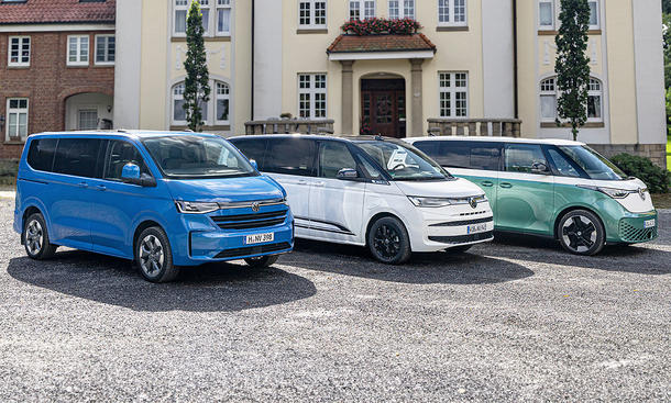 VW T7 Caravelle, T7 Multivan und ID. Buzz stehen nebeneinander auf einem Schotterparkplatz.