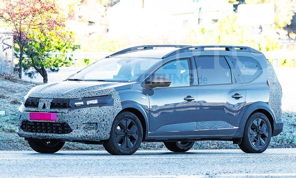 Das Dacia Jogger Facelift (2025) fährt eine kurvige Landstraße entlang. Blick von seitlich-vorne.