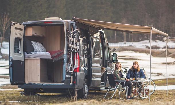 Die Außenaufnahme zeigt den stehenden Hannes Camper Van 60 (2024) mit geöffneten Hecktüren. 