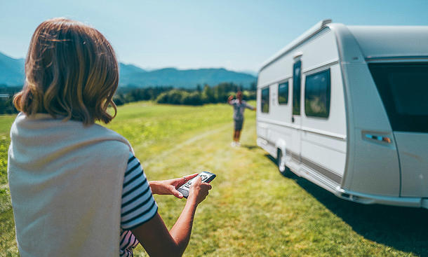 Mover für Wohnwagen; Person steuert einen Caravan mit Mover über eine Fernbedienung