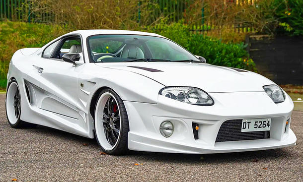 Die Toyota Supra Mk4 mit Abflug-Bodykit stehend von schräg vorne.